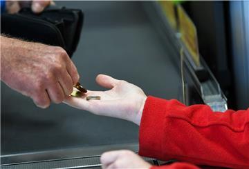 Ein Mann drückt einer Kassiererin Geld in die Hand.