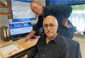 Zwei Männer stehen vor einem Computer