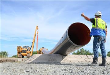 Niedersachsen, Friedeburg: Eine Baumaschine verlegt Rohre für die LNG-Anbindung. Polier (Rohrleitungsbau) Bernd Kampen kontrolliert die Baustelle.