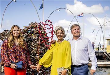König Willem-Alexander und Königin Maxima der Niederlande hängen anlässlich ihrer 21-jährigen Ehe während eines Spaziergangs zum Brionplein ein Schloss an das Punda Love Heart, während Kronprinzessin Amalia neben ihnen steht. 