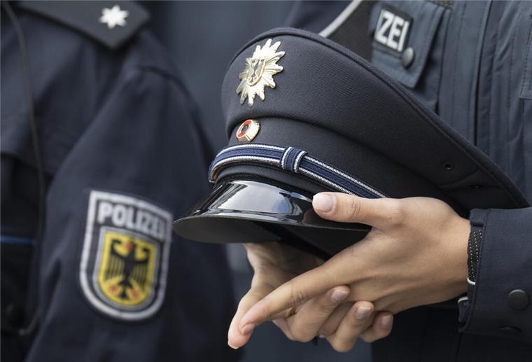 Polizisten in Niedersachsen bekommen mehr Geld für Uniform Eine junge Bundespolizistin hält bei der Vereidigungsfeier der Bundespolizeidirektion auf dem Flughafen Frankfurt ihre Mütze in den Händen.
