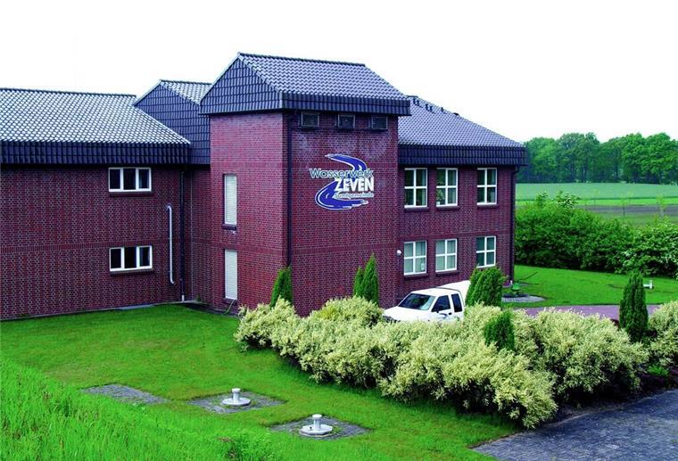 Ein rotes Gebäude trägt ein Logo mit der Aufschrift "Wasserwerk Zeven". 