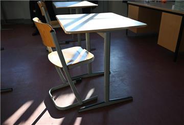  Ein Schreibtisch steht im sonnendurchfluteten Klassenzimmer.