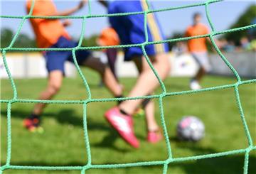 Kinder spielen Fußball.  Fußball, Skifahren und Radfahren führen die Unfallstatistik an – mit teils schweren Folgen. Prävention wie Aufwärmen und Schutzausrüstung kann das Risiko deutlich verringern.