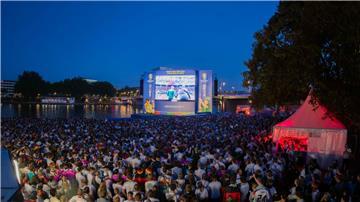 Fußballfans verfolgen ein EM-Spiel in der Fanzone am Mainufer.