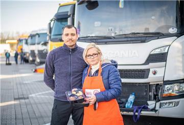 Gaby Treschok von der Bremerhavener Tafel versorgt den ukrainisch-stämmigen Lkw-Fahrer Maxim mit gespendetem Essen. 