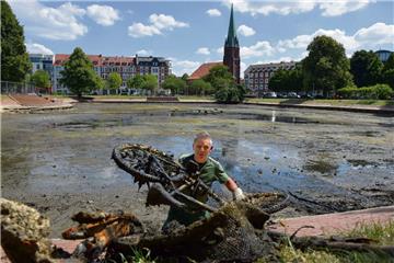 Gartenbauamtsmitarbeiter befreiten am Montag den Holzhafen in Bremerhaven von Müll und jeder Menge entsorgten Gegenständen. Die Wasserfläche ist inzwischen auf wenige Pfützen geschrumpft.