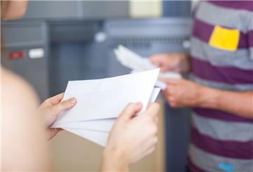 Eine Frau hölt drei geschlossene Briefe in der Hand