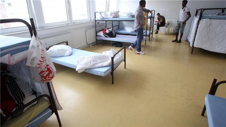 Geflüchtete halten sich in ihrem Vielbettzimmer auf.