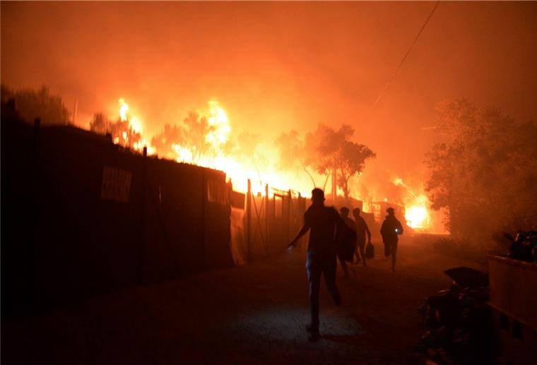 Flüchtlingslager Moria steht in Flammen Geflüchtete rennen während ein Feuer im Flüchtlingslager Moria auf der Insel Lesbos brennt. Medienberichten zufolge stehen auch Wohncontainer in Flammen, weshalb die Behörden das Lager evakuierten.