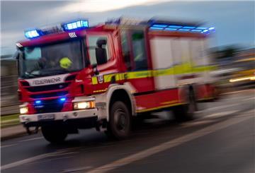 Ein Fahrzeug der Feuerwehr fährt mit Sonderrechten (Blaulicht) über eine Straße.