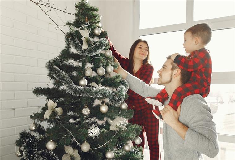 Familie schmückt Weihnachtsbaum