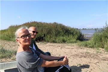 Genießen den Vormittag an der Weser mit Hund „Ben“: Beate Neidert-Müller (65) und ihr
Mann Karl Müller (67) .