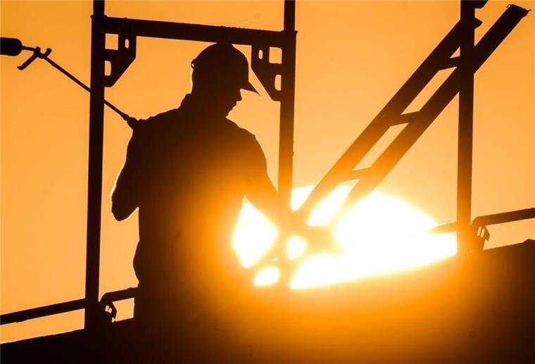 Mann auf Gerüst vor Sonnenuntergang