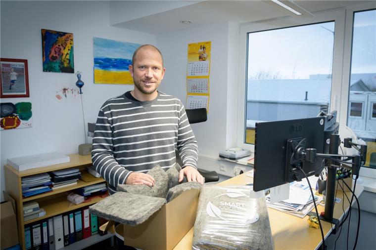 Geschäftsführer Dr. Florian Siedenburg zeigt den mit dem Kunststoffvlies ausgelegten Karton. 