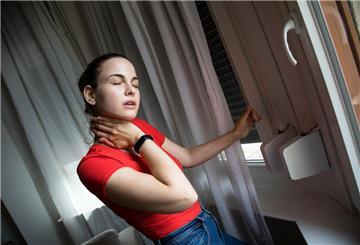 Eine Frau lässt Rollläden herunter. Geschlossene Rollläden halten Sonnenstrahlung und Hitze draußen. So bleibt die Wohnung auch an heißen Tagen angenehm kühl.
