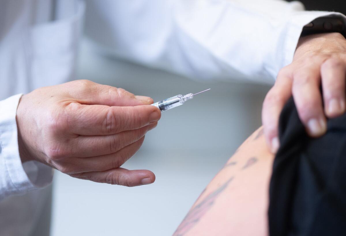 Ein Arzt setzt eine Spritze an einen Arm an. Gesundheitssenatorin Claudia Bernhard (Linke) ruft dazu auf, den Impfschutz aufzufrischen. Mit Beginn der Grippesaison steigen die Zahlen der Atemwegsinfekte im Land Bremen.