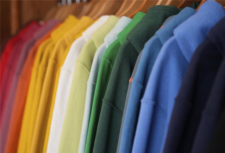 Achtung Schadstoffe! Diese Gefahren lauern in eurer Kleidung Bunte Pullover hängen an einer Kleiderstange.