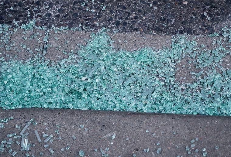 Glasscherben einer liegen auf einem Gehweg. Bushaltestellen werden in Bremerhaven und dem Landkreis Cuxhaven vermehrt Ziel von Vandalismus.