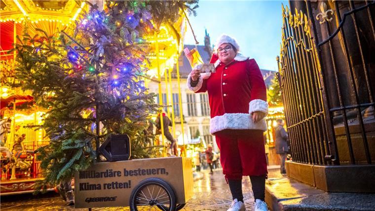 Baum mit Geldsäcken - Aktivisten fordern Milliardärssteuer Greenpeace Bremen hat einen „Wünsche-Tannenbaum“ aufgestellt.