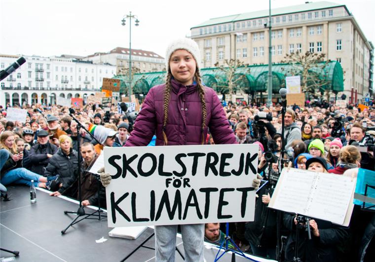 Klimaaktivistin Greta Thunberg ist in Hamburg Greta Thunberg, Klimaaktivistin, steht während einer Kundgebung in Hamburg auf dem Rathausmarkt mit einem Transparent auf einer Bühne. Die junge Schwedin ist erstmals für einen Schulstreik für mehr Klimaschutz nach Deutschland gekommen.