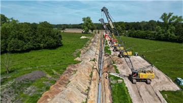 Große Baukräne hieven die Pipeline in den Rohrgraben.