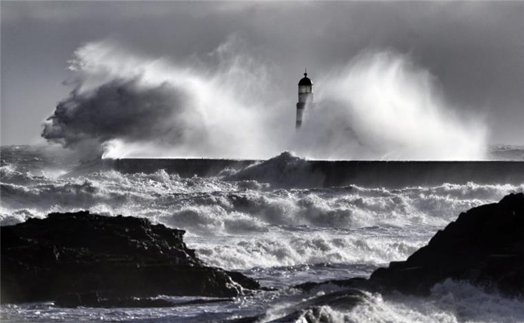 Google-Nutzer schreiben lustige Bewertungen für das Meer Große Wellen stürzen bei kaltem Wetter über einen Leuchtturm in Großbritannien.