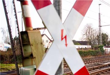 Ein Andreaskreuz steht an einem Bahnübergang.