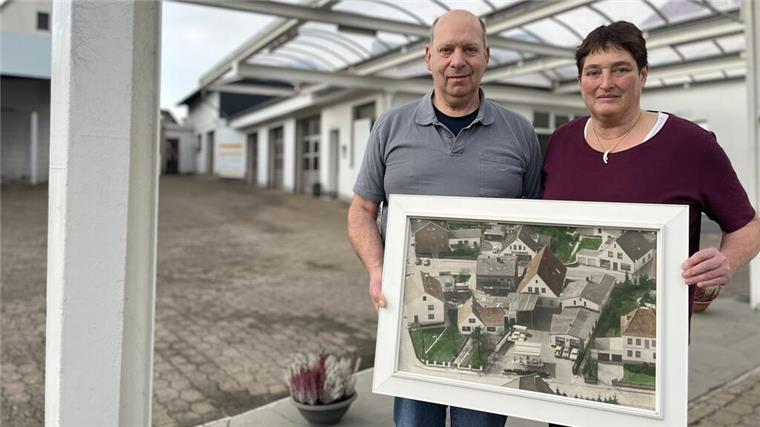 Zwei Menschen mit einem großen Bild in den Händen. 