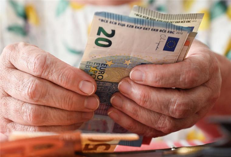 Eine ältere Frau hält mehrere Geldscheine in der Hand. Rentner können sich freuen: Im August 2025 erhalten sie die Rente schon früher. 