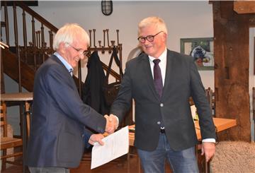 Das Foto zeigt, wie der Ratsälteste Klaus Huhn Bürgermeister Diedrich Höyns gratuliert. 