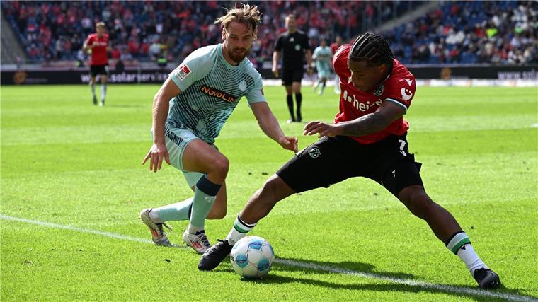 Hannovers Jessic Ngankam (r) schirmt den Ball vor Kaiserslauterns Jannis Heuer ab.