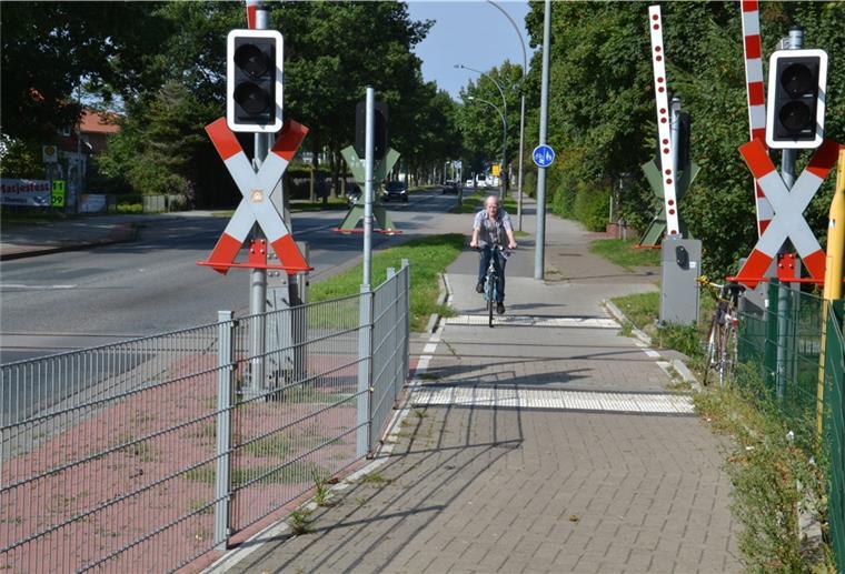 Hans Kist überquert mit seinem Fahrrad den Bahnübergang im Verlauf der Kivinanstraße.