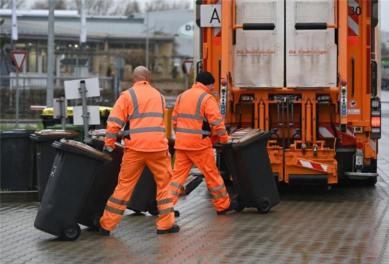 Haushalte unter Druck! Hier steigen Müllgebühren auf mehr als 552 Euro Mehrere Müllwerker schieben Mülltonnen zum Müllwagen.