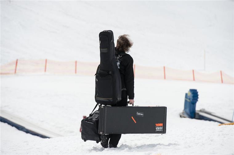 "Wacken on Ice" - Das "Full Metal Mountain"-Festival Heavy Metal - schweres Gepäck: Ein Musiker trägt im Ski-Gebiet Nassfeld in Österreich während des "Full Metal Mountain" Festivals Gitarren zur Tresdorfer Alm.