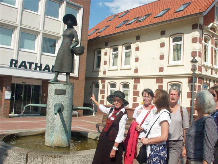 Dorfspaziergang mit Mathilde ut Beers Heike Windus alias Mathilde ut Beers erklärt das Denkmal der "einkaufenden Hausfrau" Mathilde ut Beers.