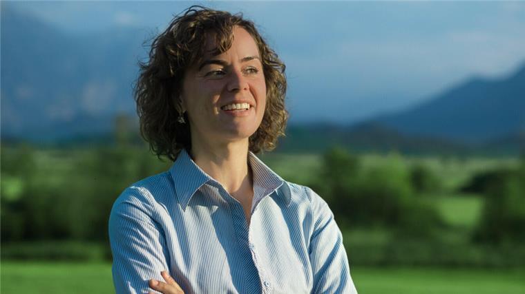 Landwirt aus dem Cuxland ist ein YouTube-Star Eine junge Frau mit braunen Locken schaut in die Ferne, im Hintergrund grüne Wiese und Berge.