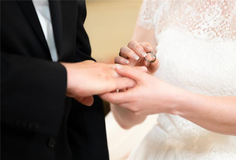 Bizarre Regel: Firma zwingt Mitarbeiter zur Ehe – oder sie fliegen raus! Ein Brautpaar vor dem Altar während der Trauung am Tag der Hochzeit