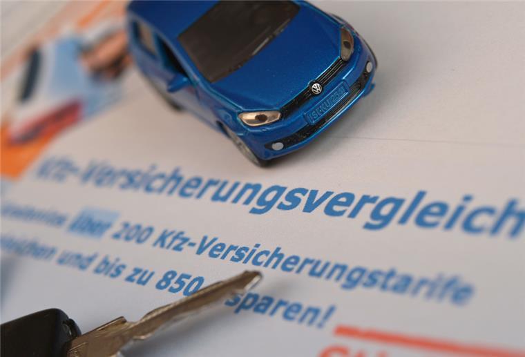 Ein Miniaturauto und ein Autoschlüssel liegen auf einem Ausdruck.