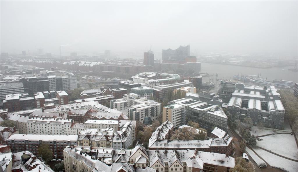 Heute kam der Winter auch zu uns in den Norden: In Hamburg liegt Schnee auf den Dächern von Gebäuden, im Hintergrund ist die Elbphilharmonie zu sehen.