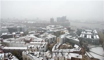 Heute kam der Winter auch zu uns in den Norden: In Hamburg liegt Schnee auf den Dächern von Gebäuden, im Hintergrund ist die Elbphilharmonie zu sehen.