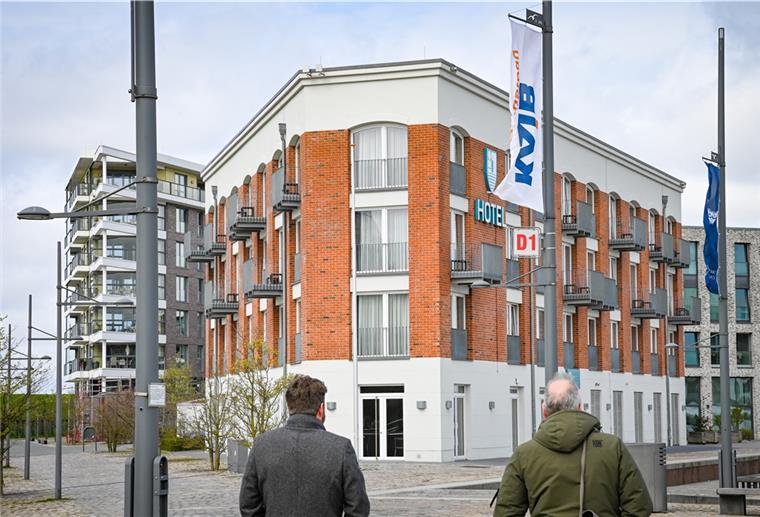 Hotel, davor Fahnenmasten und zwei Leute.