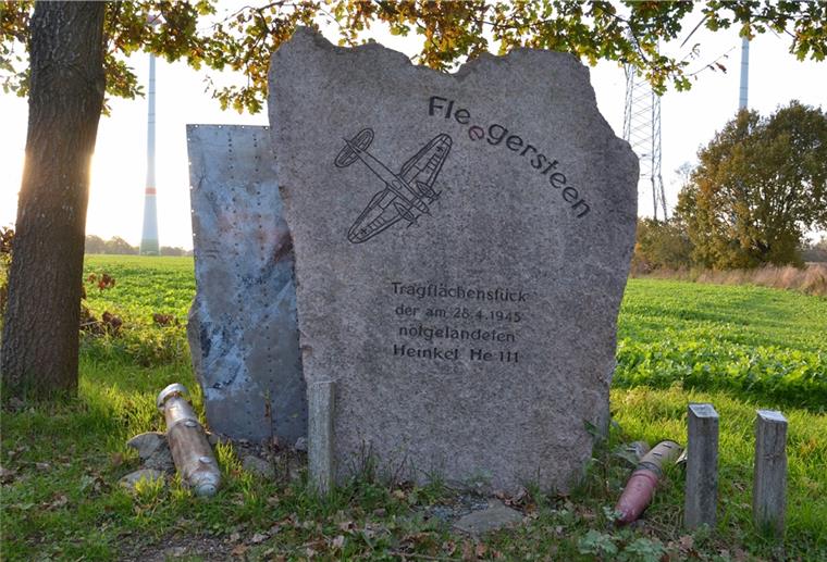 Eine Phosphorbrandbombe, eine Flak-Geschoss-Hülse und eine Alu-Platte des He-111-Bombers liegen und steht am Fleegersteen. 