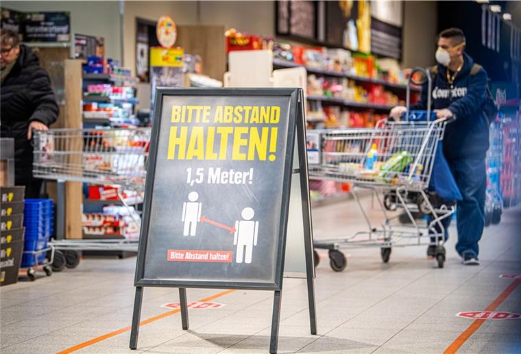Supermarkt: Kontrolle mit Einkaufswagen fehlerhaft Hinweisschilder am Eingang und entlang der Kassen weisen die Kunden auf den nötigen Sicherheitsabstand hin. Supermärkte haben unterschiedliche Ansätze, das Einhalten der Abstände sicherzustellen.