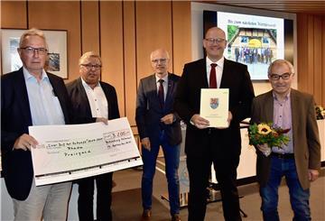 Holger Albrecht (links), Marco Mohrmann (Zweiter von rechts) und Horst Schäfer (rechts) nahmen die Urkunde, den Scheck und den Blumenstrauß für Rhade entgegen, Hartmut Leefers (Zweiter von links) und Hermann Luttmann gratulierten der kleinen Delegation.