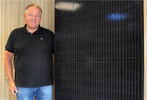 Holger Wührmann, Inhaber von Energietechnik Wührmann, neben einem Solarpaneel.