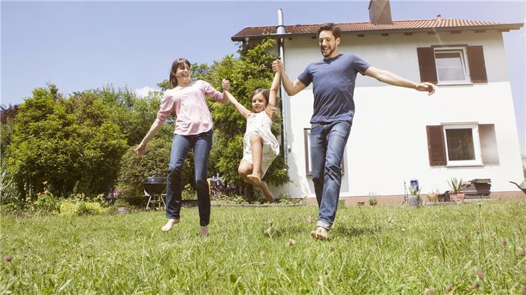 Baufirma macht pleite: Bauherr geht durch Hausbau-Hölle Fröhliche Familie auf sattem Grün.