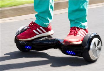 Ein Junge fährt mit einem Hoverboard auf einer Straße