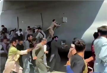Hunderte Menschen laufen neben einer Boeing C-17 der United States Air Force, die auf dem Rollfeld des Kabul International Airport fährt. Zahlreiche Afghanen, die sich nach der Machtübernahme der Taliban in Sicherheit bringen wollen, versuchten auf dem Flughafen in Flugzeuge.