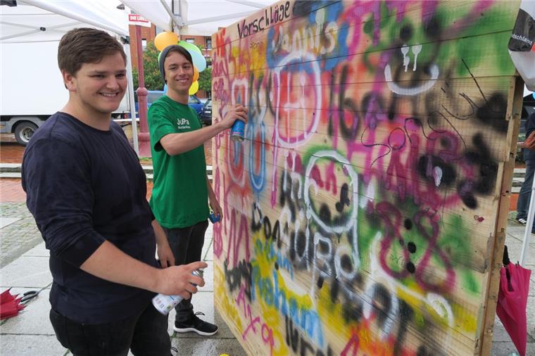 Dauerregen: NMT-Kinderfest und Sommer-Event der Sportjugend Wesermarsch fallen ins Wasser ie Vertreter des Nordenhamer Jugendparlamentes, Georg Becker (17, links) und Jannis Blumenberg (15), brachten am Samstagnachmittag den grauen Regenwolken zum Trotz Farbe ins Spiel. Sie riefen die jungen Besucher auf, eine Wand mit Farbe aus der Sprühdose zu verzieren.